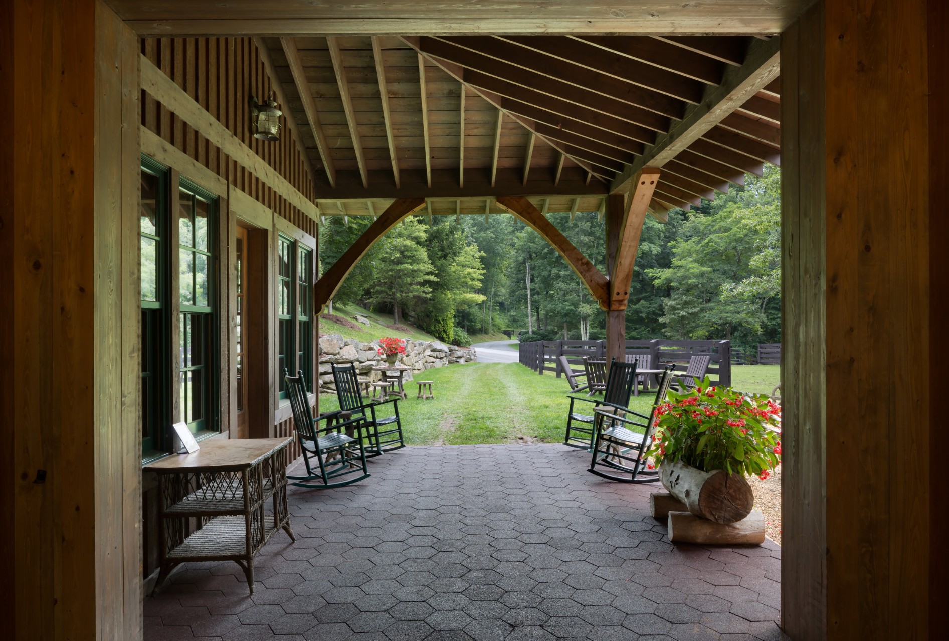 Covered walkway with exposed timber frame ceiling and iron chandeliers